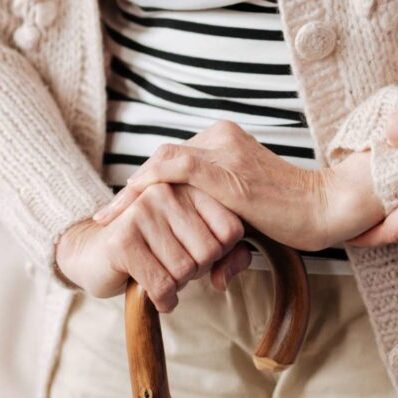 carer helping elderly woman to stand